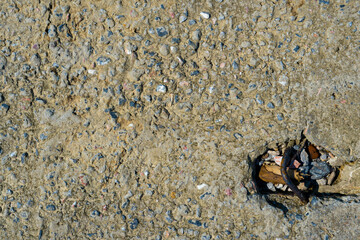 Old concrete slab with a metal bracket stuffed with stones and debris texture or background