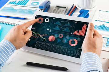 Obraz na płótnie Canvas Businessman with a computer tablet at a work desk