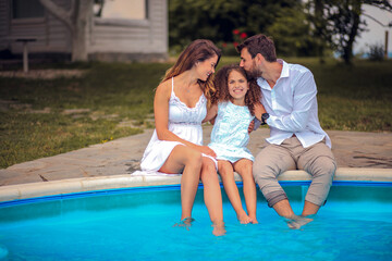 Fototapeta na wymiar Family sitting by the pool.