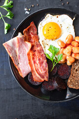 english breakfast fried egg black pudding blood sausage, cereal bread, beans scrambled eggs, on the table wholesome food healthy meal snack copy space food background rustic. top view