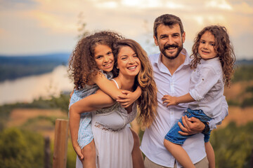 Portrait of the smiling family standing in the vineyard. Time with family.