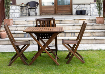 wooden table and chairs on the garden lawn