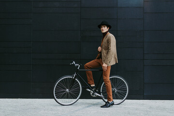 Handsome young business man with his modern bicycle.