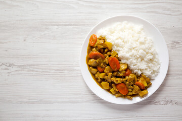 Homemade Japanese Chicken Curry  on a white plate on a white wooden background, top view. Flat lay, overhead, from above. Copy space.