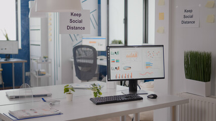 Modern empty office interior with plastic separators and keep social distance poster on the walls. Empty corporate space business interior with nobody in it