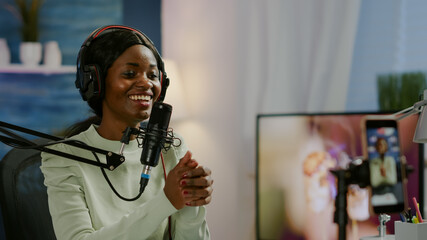 African vlogger recording video blog using smartphone with modern equipment in home studio podcast....