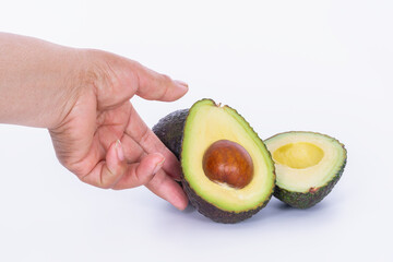 Hand touching an avocado cut in half: Selective focus and close up. Healthy food concept.