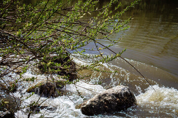 Strong river current, splash of water, waves and large stones.