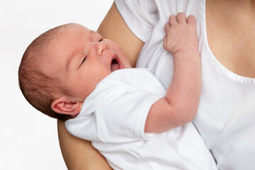 A newborn baby for 1 week lies in the arms of the mother. Close-up. Love and tenderness.