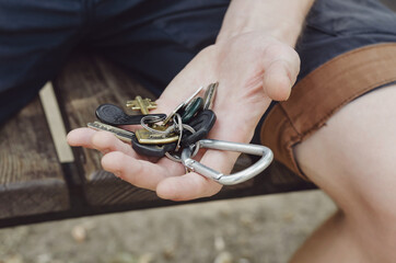 A young adult holds a bunch of keys in his hand.