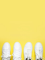 White sneakers on yellow background top view flat lay. Stylish youth women's leather sneakers, sports shoes, genuine leather footwear. Minimalistic shoe store advertising fashion style Shoe background