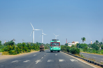 Obraz na płótnie Canvas Generic Rural Bus and pickup truck on the road and wind turbines