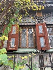 Old window in the house. Ancient wooden Russian peasant's house of 19 century.  Window with carved shutters in old cottage.