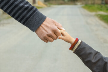 A beautiful hands of parent and child outdoors in the park