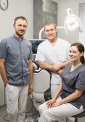 Obraz premium A group of friendly dentists in the office of a modern dental clinic