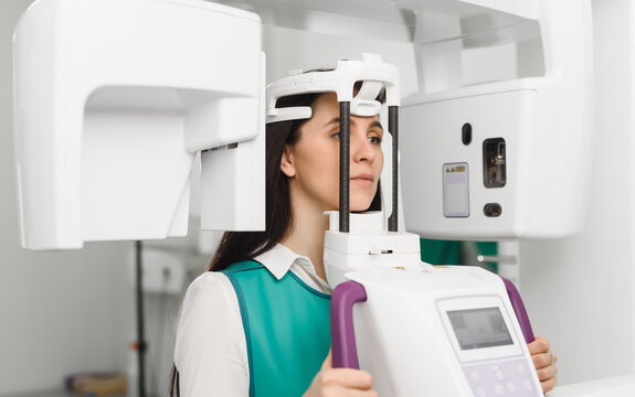 Young woman ready to computer 3d tomography of teeth and jaw in modern dental clinic