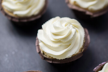 Top view  cupcakes  with white butter cream on dark background.