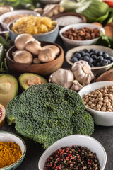 Choice of fresh food and healthy eating focused on broccoli. Vegetables, fruits, legumes and cereals on a concrete table