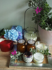 Candles and flowers are placed on a wooden table with decorations, giving a feeling of warmth and wanting to be at home.