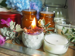 Candles and flowers are placed on a wooden table with decorations, giving a feeling of warmth and wanting to be at home.