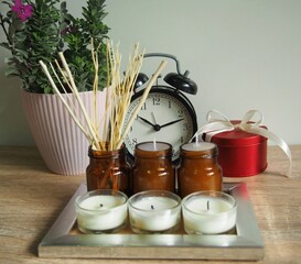 Candles and flowers are placed on a wooden table with decorations, giving a feeling of warmth and wanting to be at home.