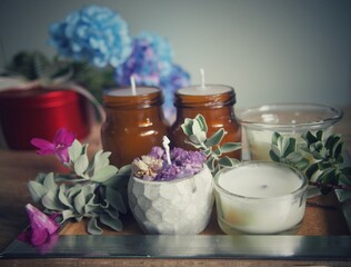 Candles and flowers are placed on a wooden table with decorations, giving a feeling of warmth and wanting to be at home.