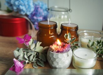 Candles and flowers are placed on a wooden table with decorations, giving a feeling of warmth and wanting to be at home.