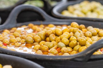 Green olives in bulk bucket ready for sale, food concept
