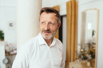 Middle-aged man standing daydreaming with serious expression