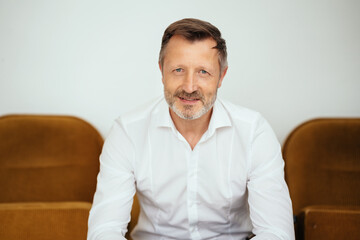 Attractive bearded middle-aged man looking pensively at camera