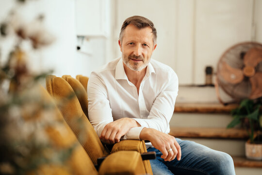 Relaxed casual trendy middle-aged man staring at the camera