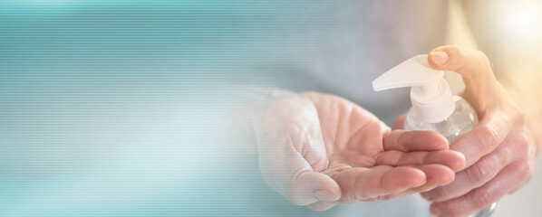 Hand pressing on sanitizer bottle; prevention of virus and bacteria infection; panoramic banner