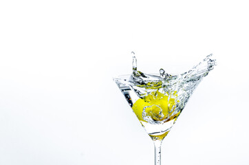 Close-up of water drop falling into a glass on white background