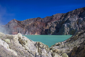 Sulfuric acid lake and gas coming out of the sulphur mines in the crater on the bottom of Mount Ijen active volcano, Banyuwangi, East Java, Indonesia. 