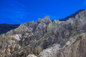 Steep volcano crater walls and the dangerous road, where many travelers hiked, climbing up to the top of Mount Ijen or descending to the bottom of sulfur crater. 
Banyuwangi, East Java, Indonesia. 