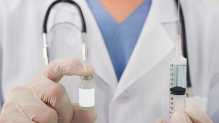 Selective focus of Doctor's hand holds a syringe vaccine bottle at the hospital. Health and medical concepts