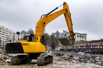 An excavator among a pile of garbage after dismantling an illegally constructed building.