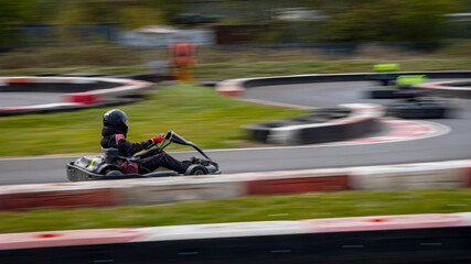 A panning shot of a racing kart as it circuits a track.