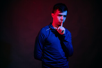 Emotions of a guy in a studio with blue and red light on a black background