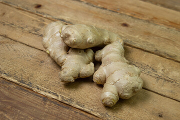 Ginger on a wooden background. Ginger root. Three whole ginger next to each other