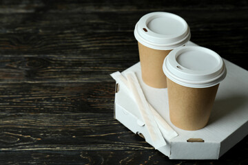 Pizza box and paper cups on wooden background