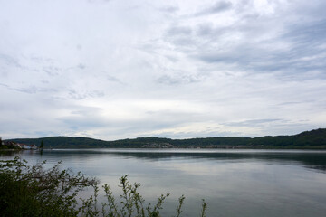 view of lake constance with clouds, mountains and trees