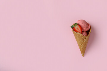 Cone of strawberry ice cream on pink background