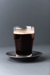 Coffee in glass cup on gray background. Close up.	