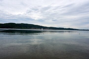 panaroma shot of lake constance with clouds, mountains and trees