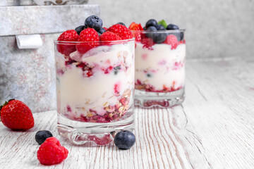 Muesli with yogurt and berries in a glass On a wooden table. Fitness food. Copy space.