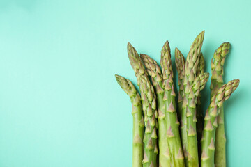 Fresh green asparagus on mint background, space for text
