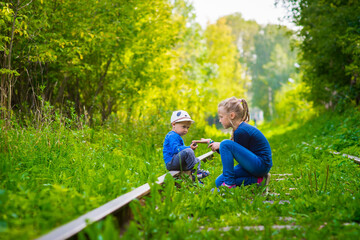 girl and boy sitting on an old railroad, summer, outdoor walks happy childhood selective focus