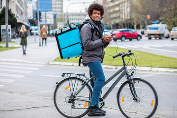 Male courier with bicycle delivering packages in city.