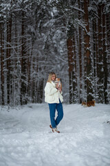 Fototapeta na wymiar Blonde young female with ginger white chihuahua and welsh corgi pembroke in a snowy forest in winter